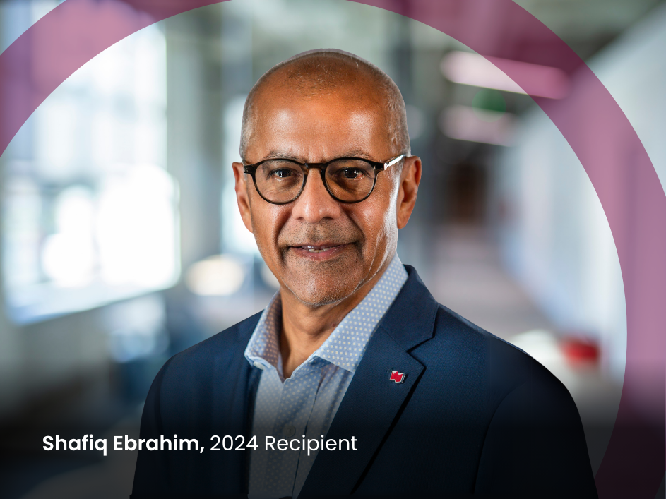 Headshot of Shafiq Ebrahim, a smiling man with glasses, wearing a navy suit with '2024 recipient' text.
