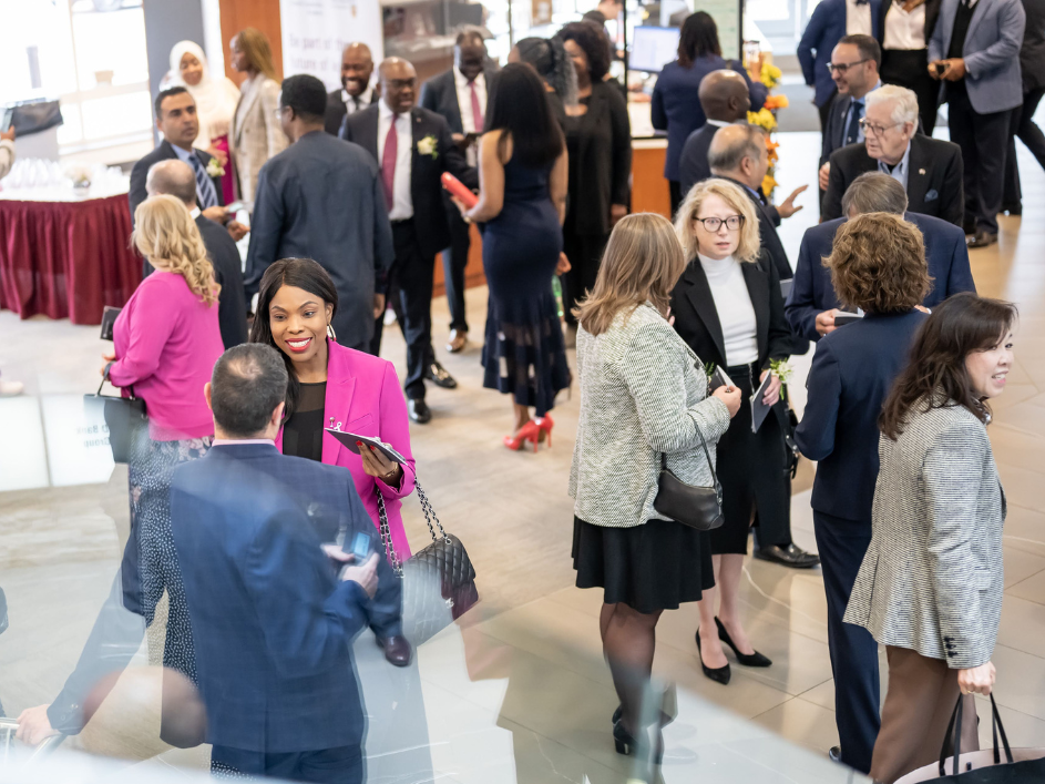 Groups of TDC alumni conversing in an event hall.