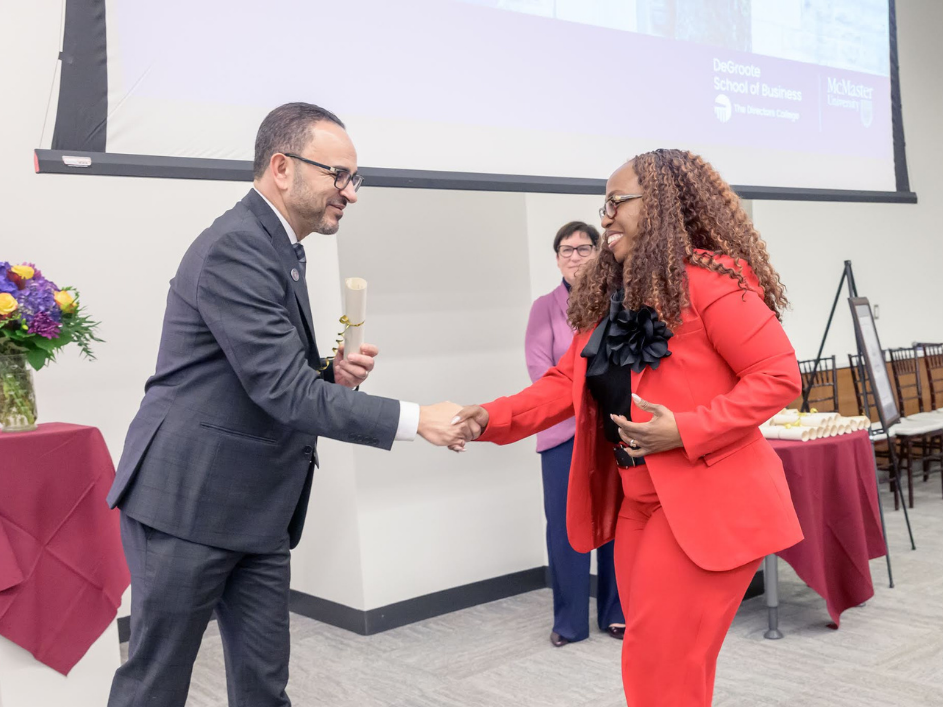 A student shaking hands with a faculty member.