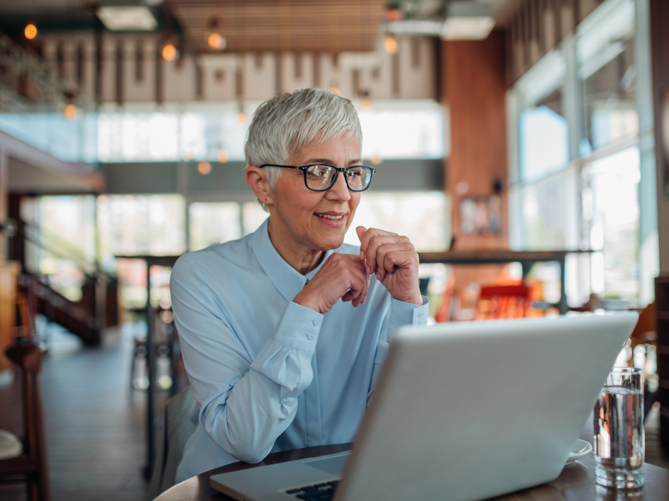 A senior professional looking at a laptop.