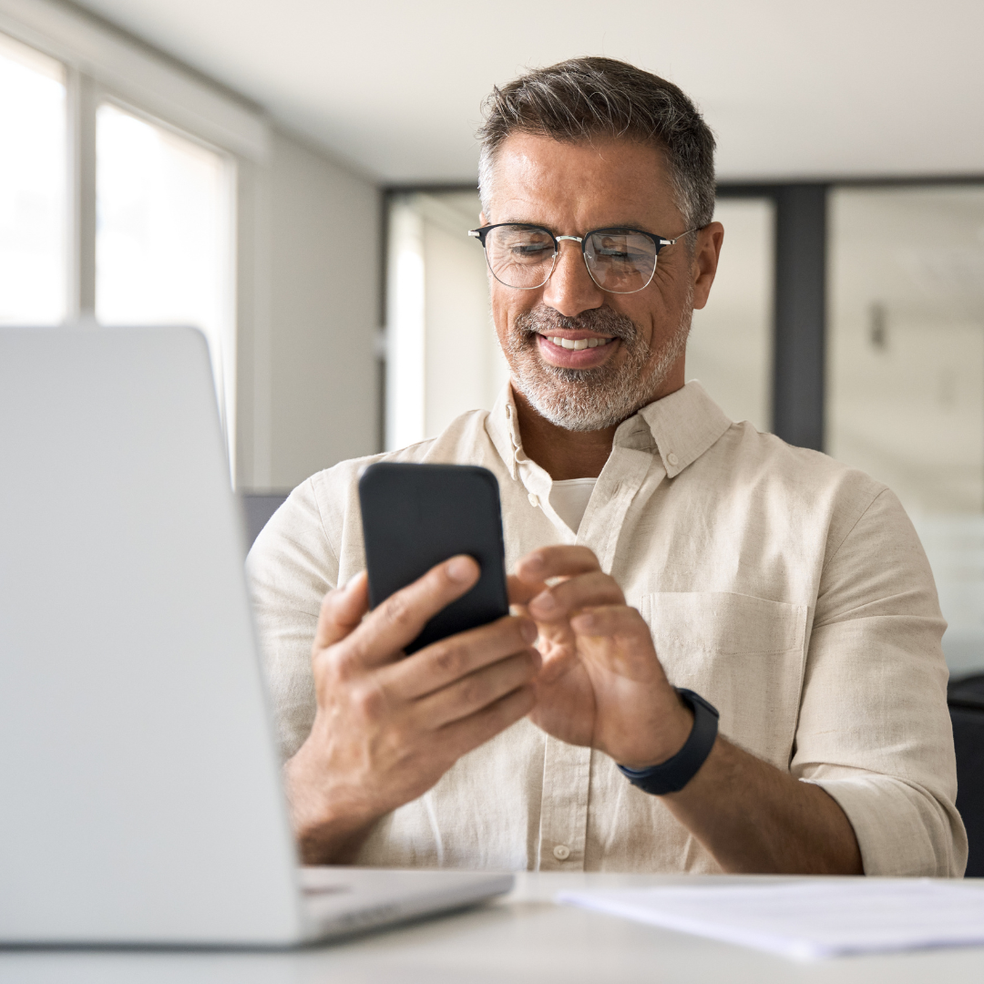 A senior professional using a phone at their desk.