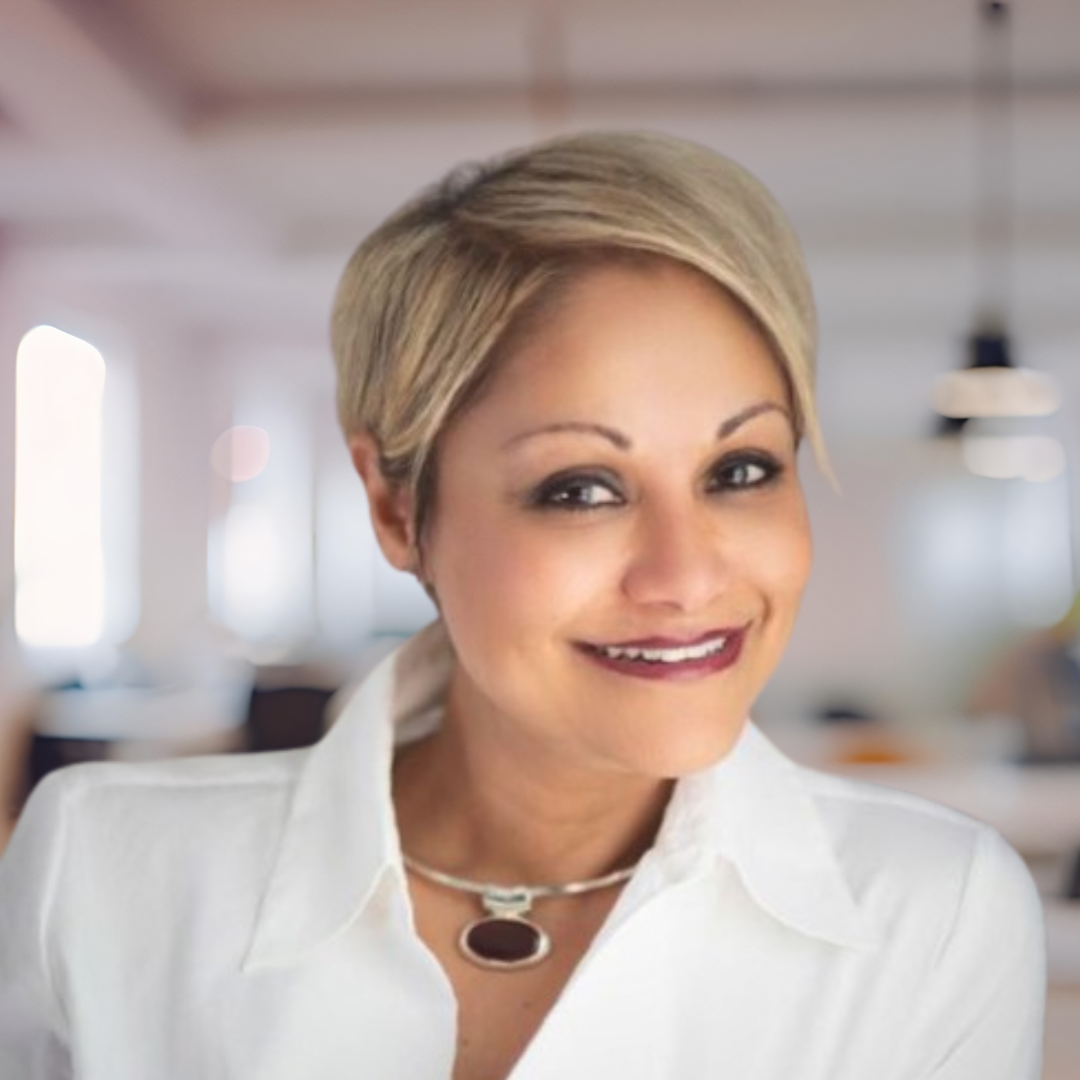 Portrait of Narissa Sawh, a smiling woman with short, blonde hair, wearing a white blouse.